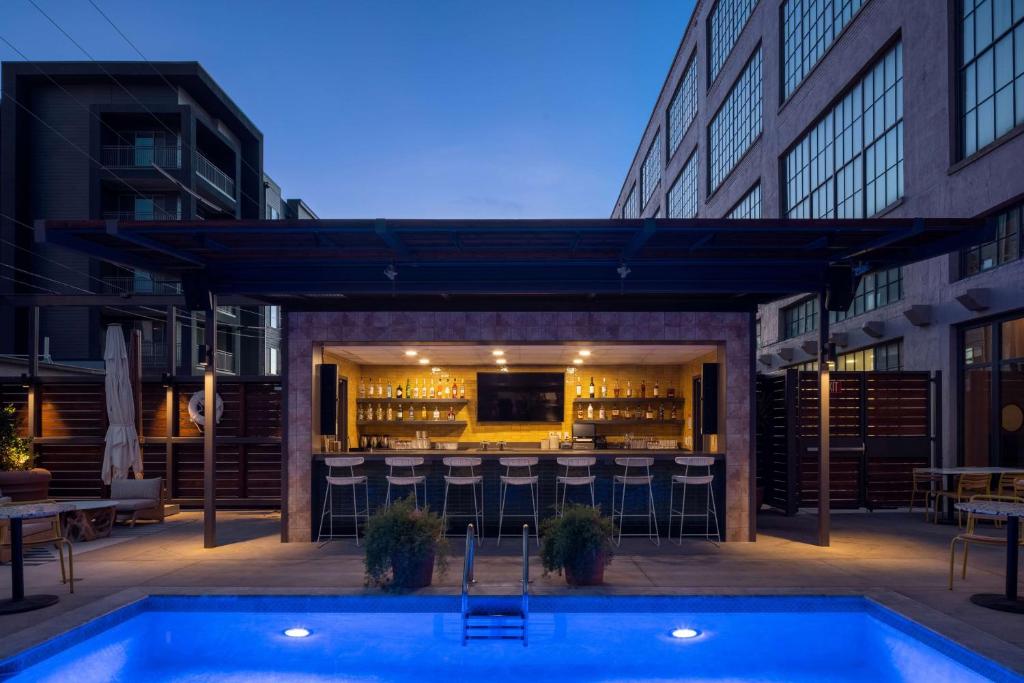 a patio with a bar and a swimming pool at Fordson Hotel, in the Unbound Collection by Hyatt in Oklahoma City