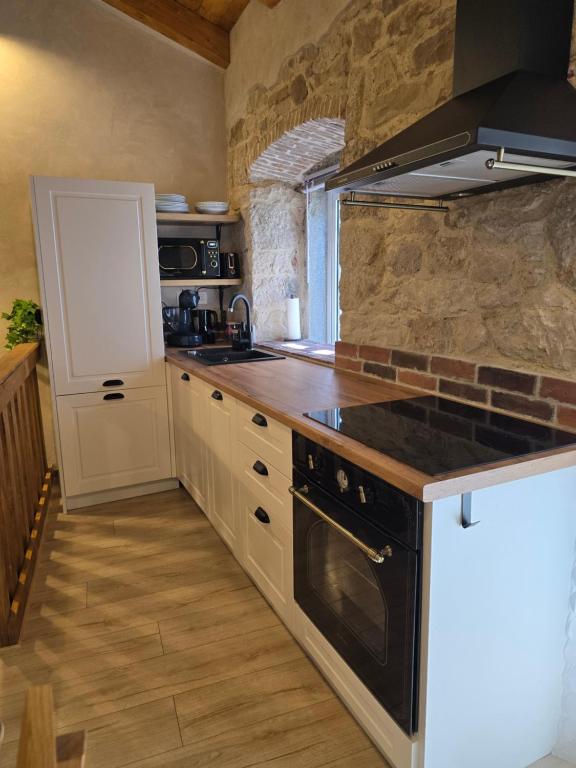 a kitchen with a stove and a counter top at Apartments Rose 5 in Cres