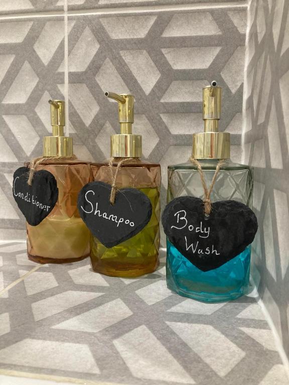 three bottles of soap sitting next to each other at Lime Tree Cottage in Tillingham