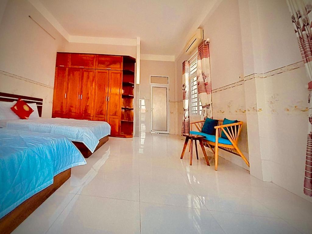 a bedroom with a bed and a chair in it at Anna Homestay in Ðông Tác (1)