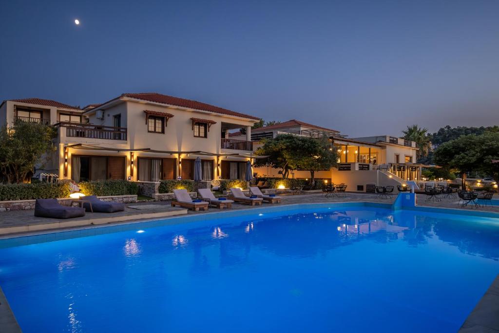 a large swimming pool in front of a house at Skopelos Holidays Hotel by GHH in Skopelos Town