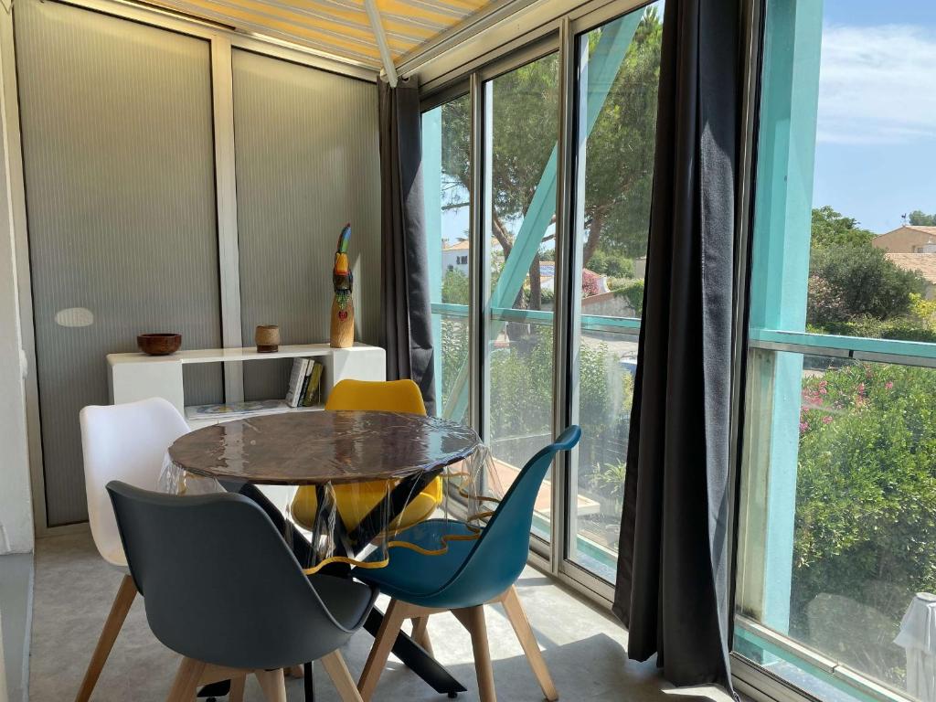 une salle à manger avec une table et des chaises et une fenêtre dans l'établissement Agréable T2 climatisé avec Loggia, Parking, et Wifi à Balaruc-les-Bains - FR-1-553-250, à Balaruc-les-Bains