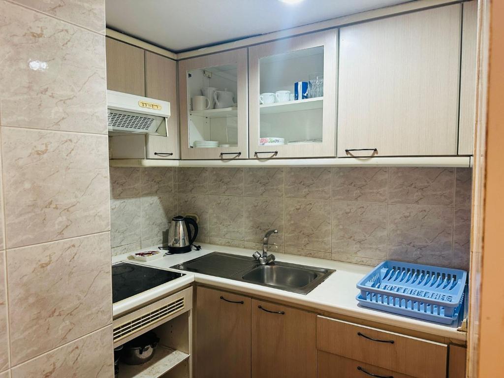 een kleine keuken met een spoelbak en een aanrecht bij Affordable Serviced Apartment Nana - Omni Tower Sukhumvit location in Bangkok