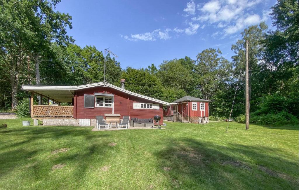 a red cabin in the middle of a yard at 2 Bedroom Awesome Home In Ljungby in Ljungby
