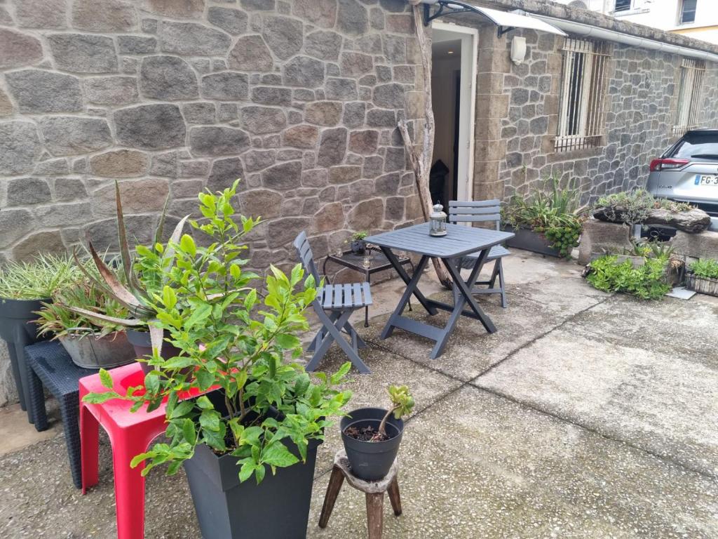 un patio avec une table et des plantes en pot dans l'établissement Nid d'amour, à Bastia