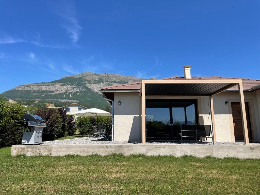 a house with a porch with a mountain in the background at LE PIC PONCON in Gap