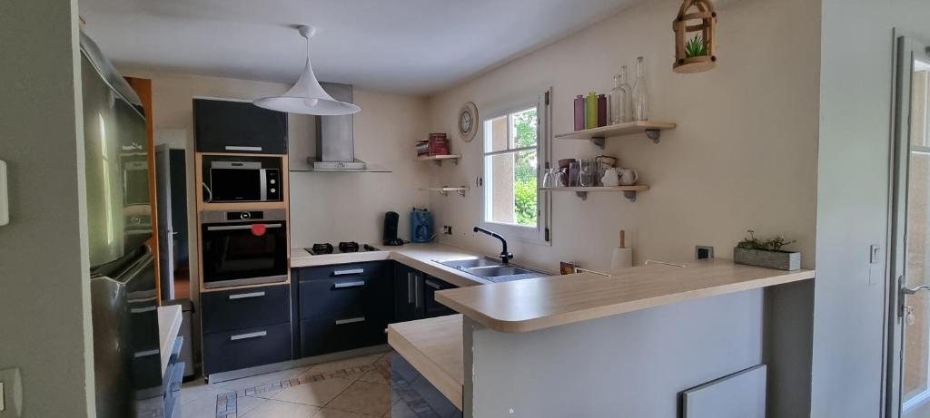 une cuisine avec des armoires bleues et un comptoir dans l'établissement Maison proche mer, à Pleurtuit