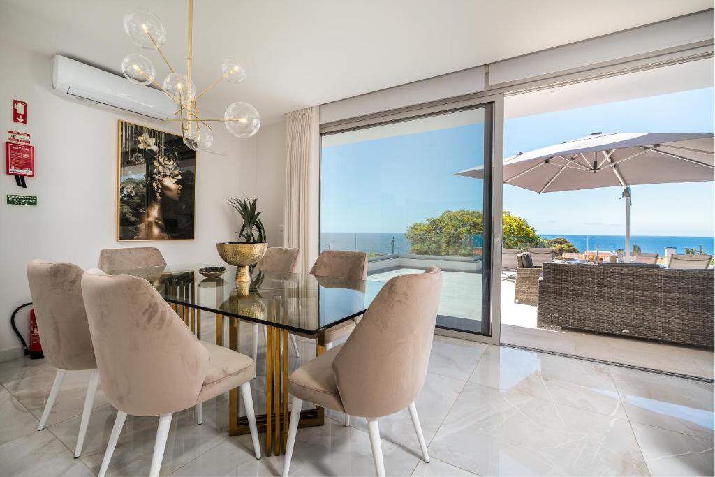een eetkamer met een glazen tafel en stoelen bij El Dourado House in Reis Magos