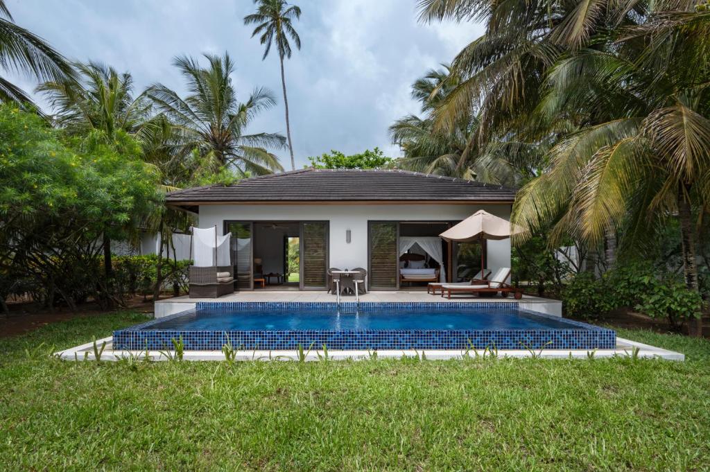 a swimming pool in front of a villa at The Residence Zanzibar in Kizimkazi