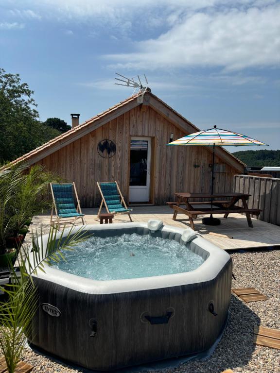 a hot tub in a yard with two chairs and an umbrella at Rooftop in Jaure