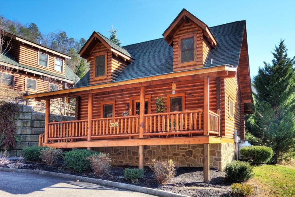 a large wooden house with a large deck at Gorgeous Cabin Hot Tub, Fireplace, Great Location in Sevierville