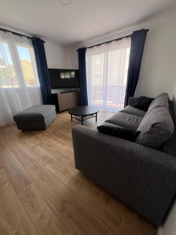 un salon avec un canapé et une table dans l'établissement L'azur Elite - T4 proche mer - Terrasse - Parking, à Sète