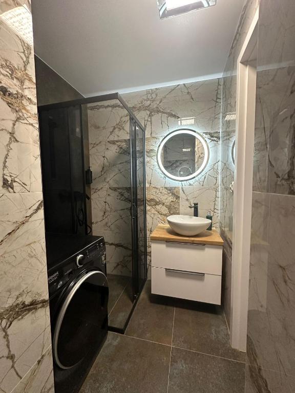 a bathroom with a sink and a washing machine at Apartament Klimatyzacja nr 1 in Radom