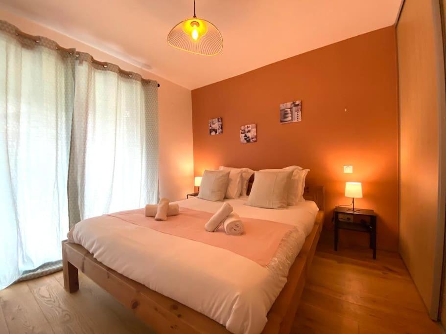 - une chambre avec un grand lit blanc et des oreillers blancs dans l'établissement Astoria - parking, vélos, jardin et terrasse, à Annecy