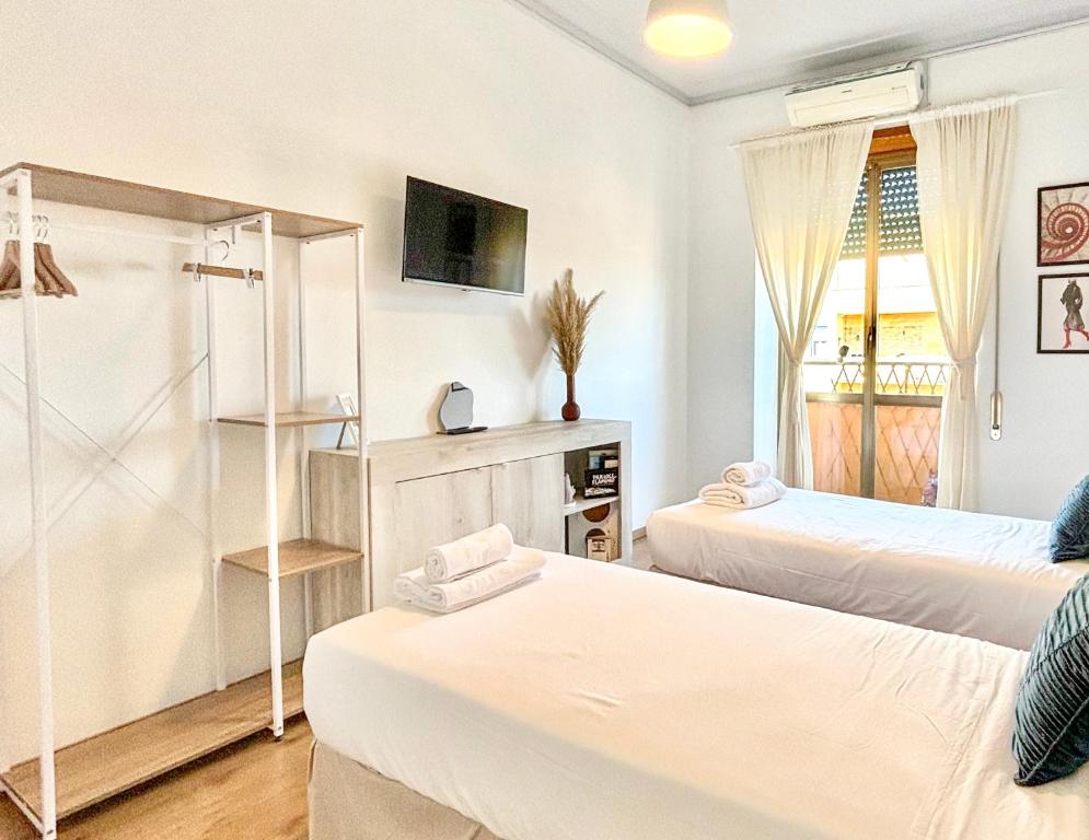 a white room with two beds and a tv at Flaminio Luxury Home - City Center in Rome