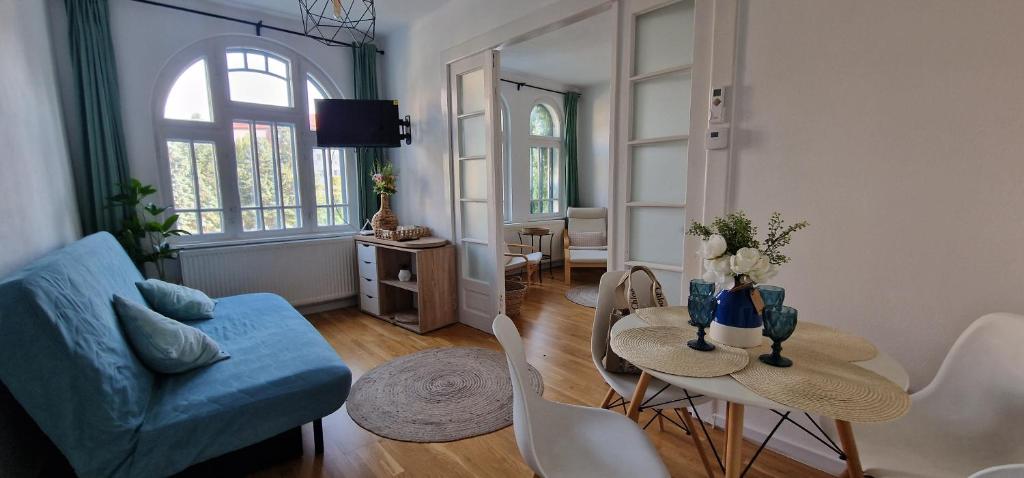 a living room with a table and a blue couch at Apartament Centrul Vechi in Târgovişte