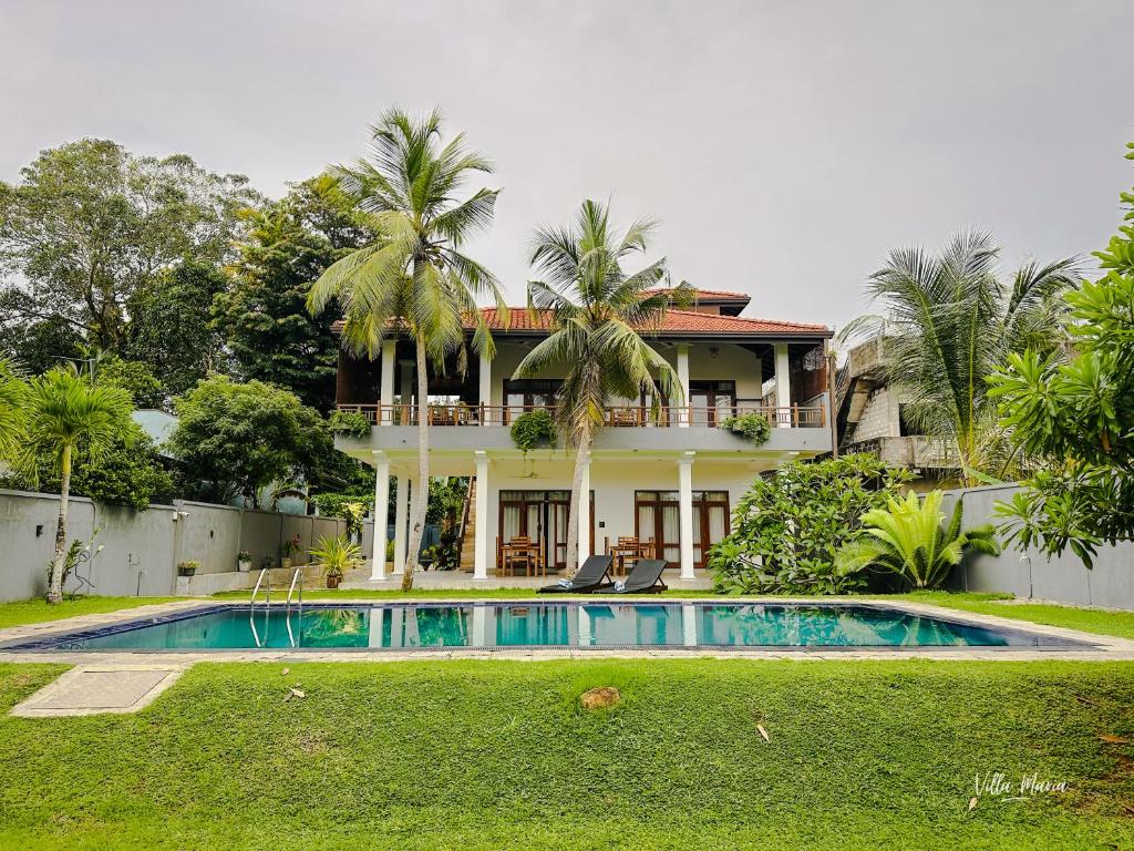 a house with a swimming pool in front of it at Villa Maria in Bentota
