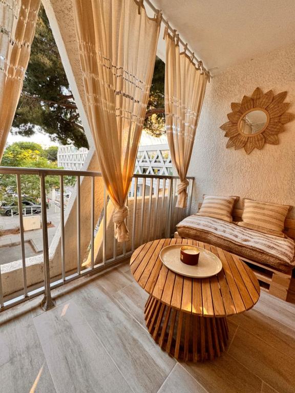 Cette chambre dispose d'un balcon avec un lit et une table. dans l'établissement Les Appartements De Lina -Studio Maya 5 - Self Check-In -, à La Grande Motte