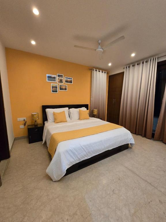 a large bedroom with a large bed with yellow walls at Two Green Park in New Delhi