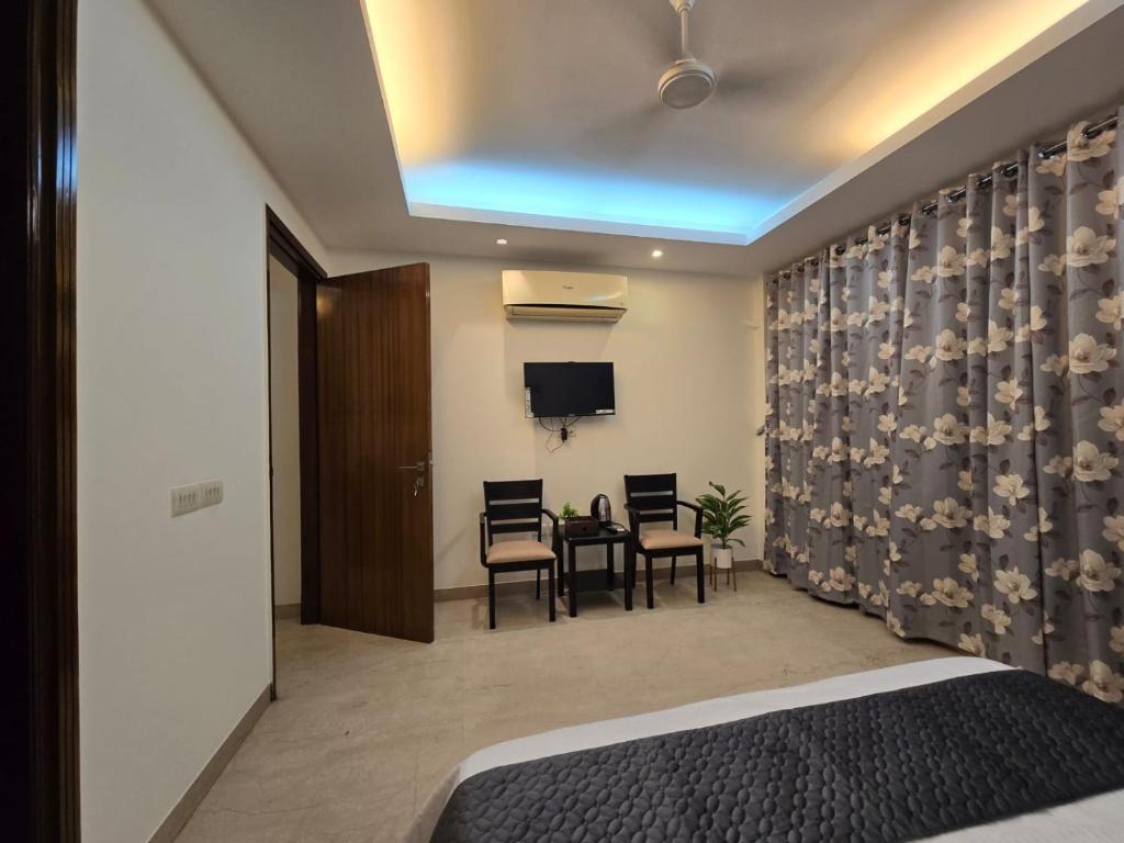 a bedroom with a bed and a table and chairs at Two Green Park in New Delhi