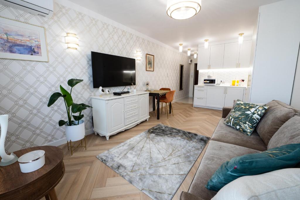 a living room with a couch and a flat screen tv at Apartament Zielona Ochota in Warsaw