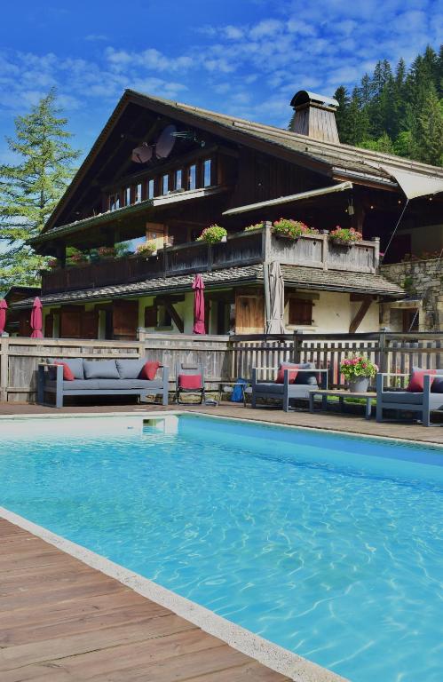 une maison avec une piscine devant dans l'établissement Les Chalets de la Serraz, à La Clusaz