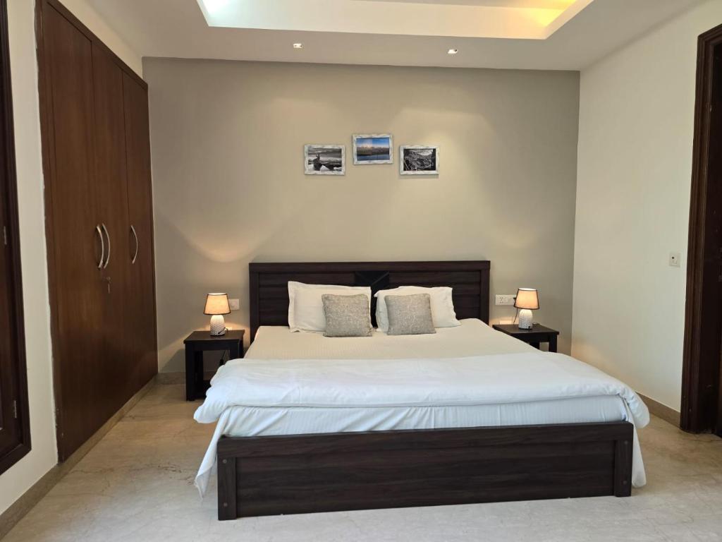 a bedroom with a large bed with two lamps at Two Green Park in New Delhi