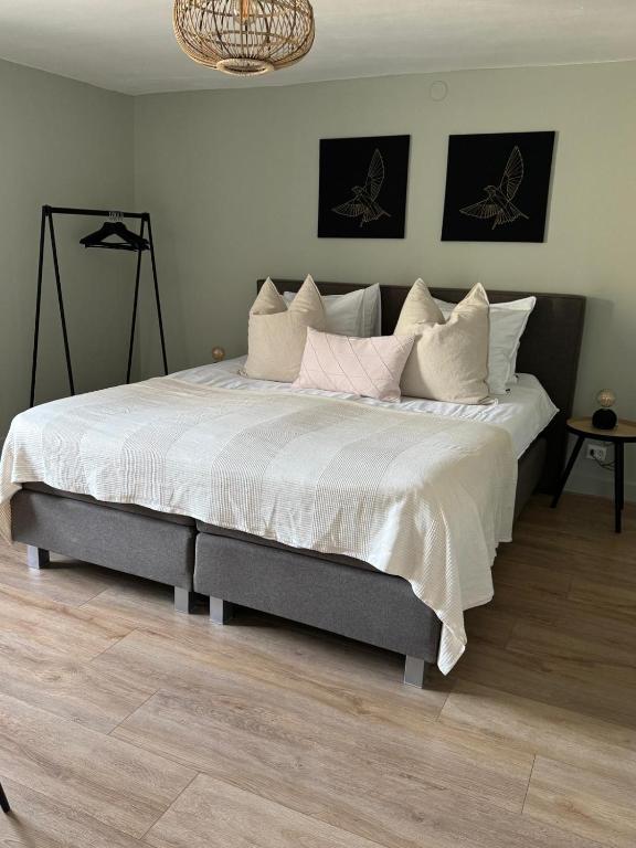 a bedroom with a large bed with white sheets and pillows at La Estancia Latinos in Valkenburg