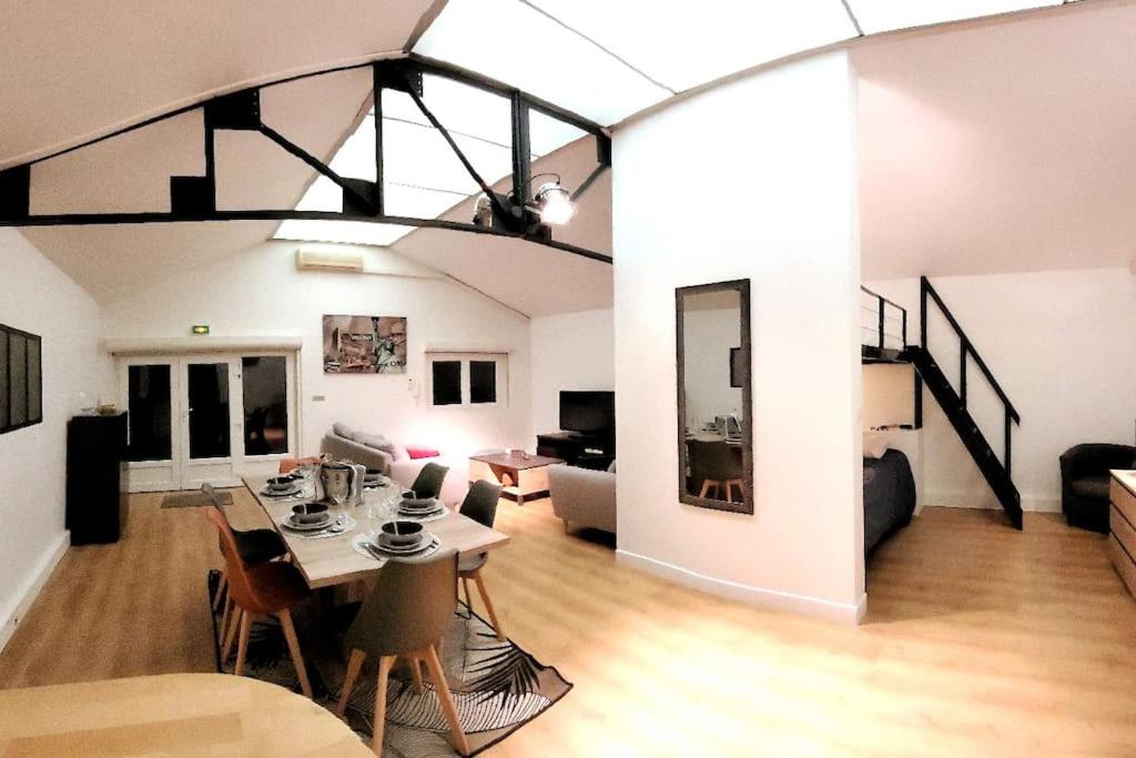 a living room with a table and a dining room at Loft proche CDG 6 pers, Parc Expo avec parking in Villeparisis