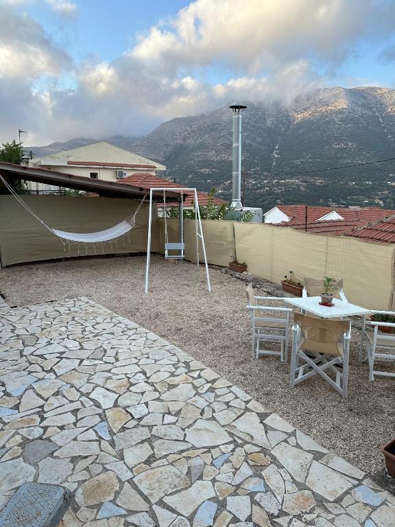 a patio with a tent and a table and a swing at Alice Apartment in Agia Effimia