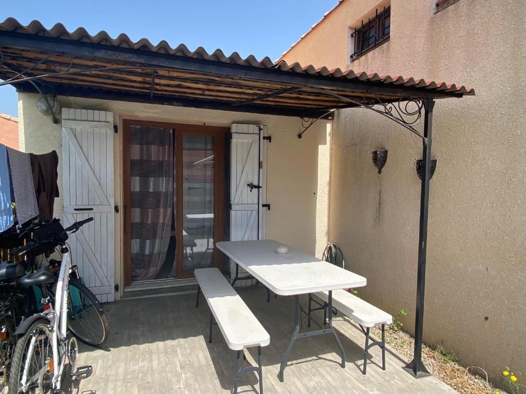 - une table de pique-nique et des chaises sur la terrasse dans l'établissement Annyck, à Gruissan