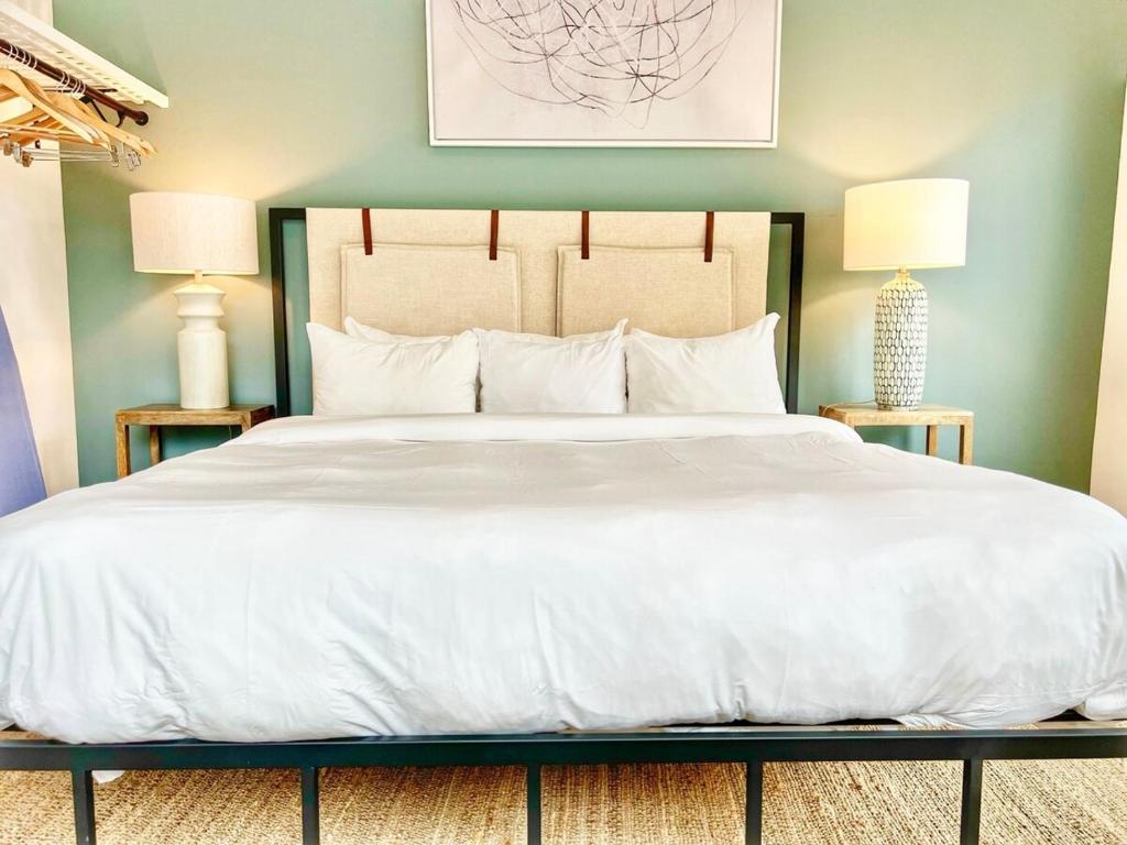 Un dormitorio con una gran cama blanca con dos lámparas. en Grand Downtown San Diego Apartment, en San Diego