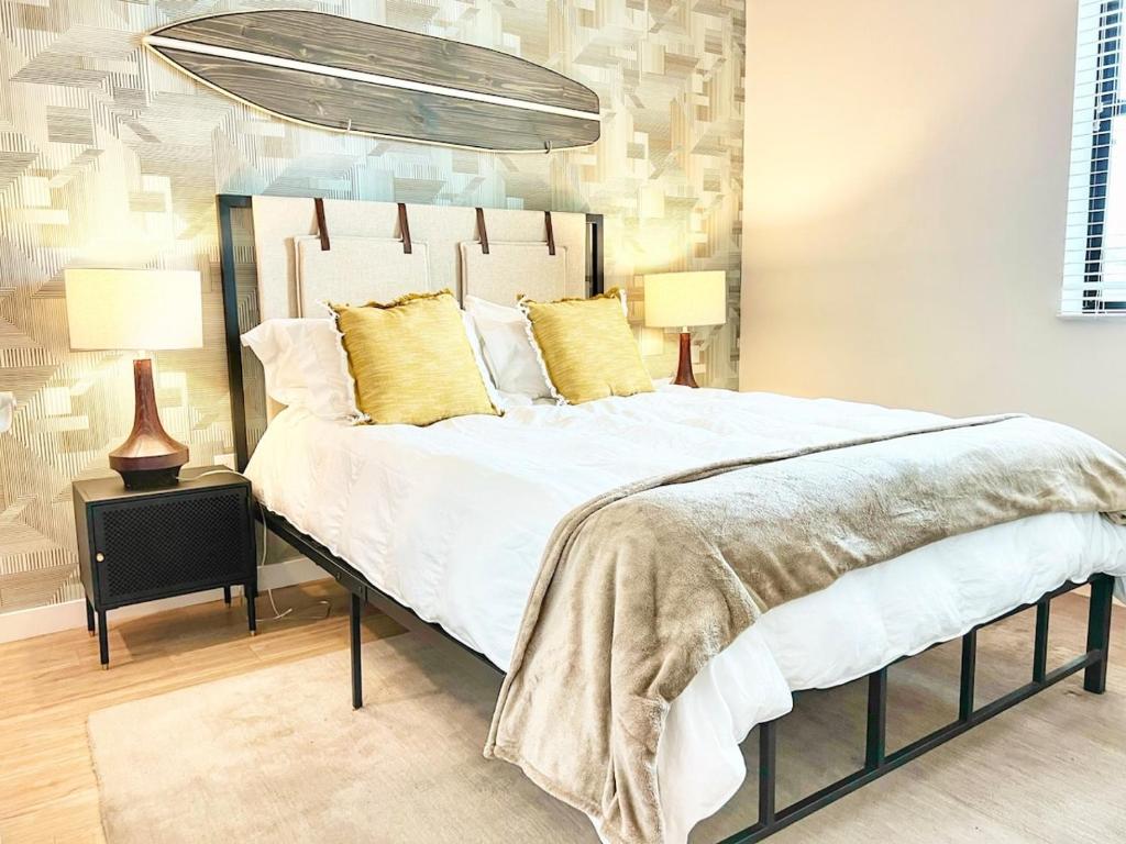 Un dormitorio con una cama grande con almohadas amarillas. en San Diego Skyline - Downtown Apartment, en San Diego