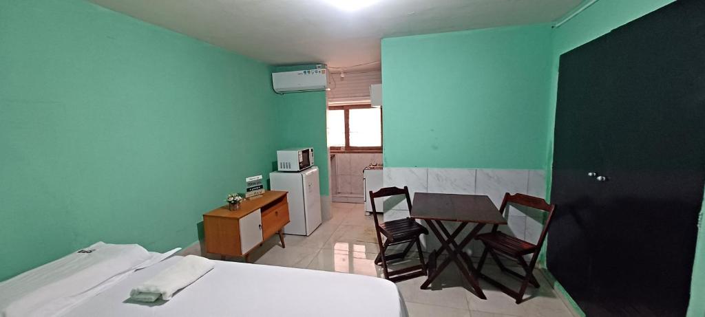 Un dormitorio con una cama y una mesa y sillas. en AP CENTRAL, en Campina Grande