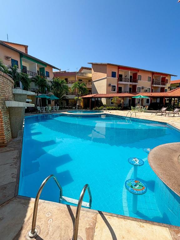 a large blue swimming pool in a resort at Vilamar Suítes in Aquiraz