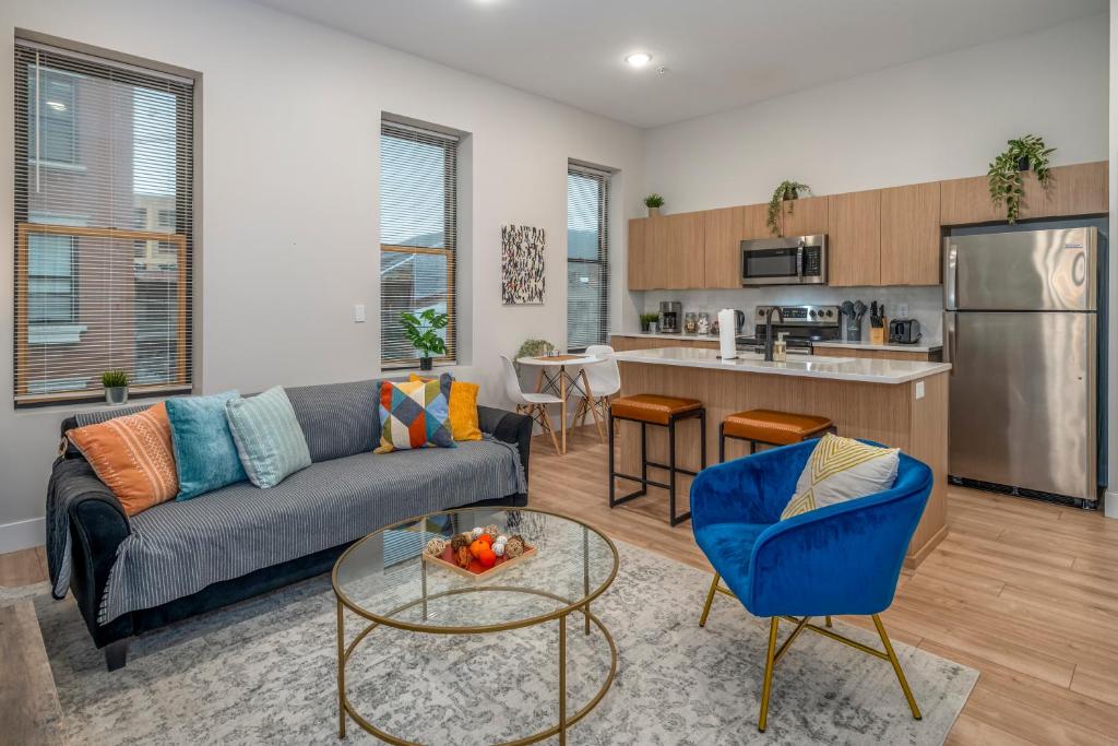 シンシナティにあるCentral Over-the-Rhine, 3 Lux Queen Beds, Steps to TQL, Findlay Market & Light Rail, Fast Wifi, Sleeps 7pplのソファとキッチンのあるリビングルーム