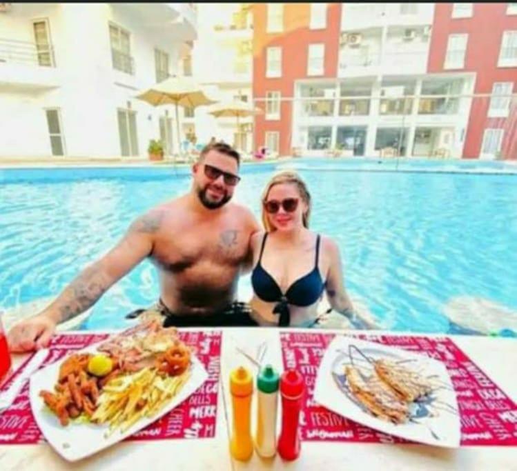 a man and a woman sitting at a table with food at Hotel Room in Aqua Palms Hurghada in Hurghada