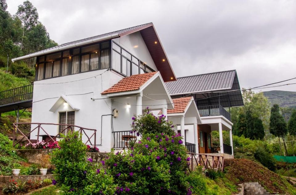 a white house on top of a hill at Vega Paradise in Kanthalloor