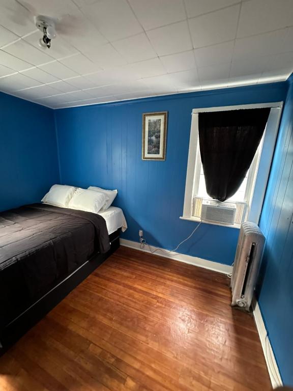 a blue room with a bed and a window at Fidelia Fuchsite Room, Queen Bed minutes from Newark Liberty international Airport and Newark Penn Station in Irvington