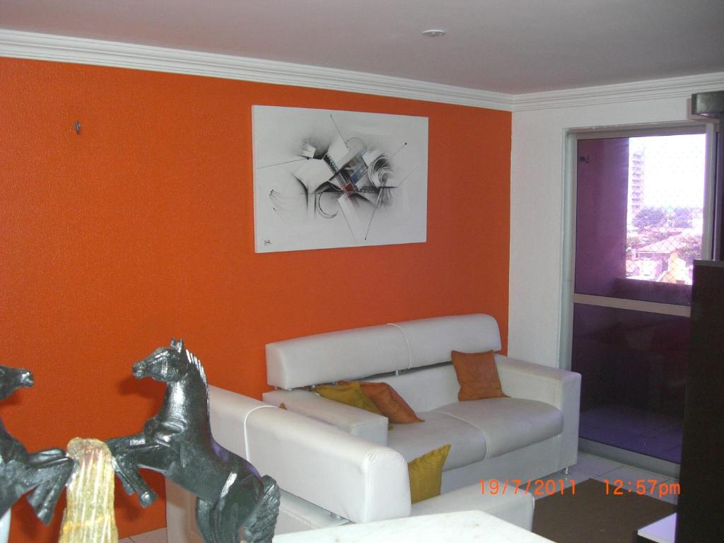 un soggiorno con divano e un cavallo sul muro di Apartamento na Praia do Futuro a Fortaleza