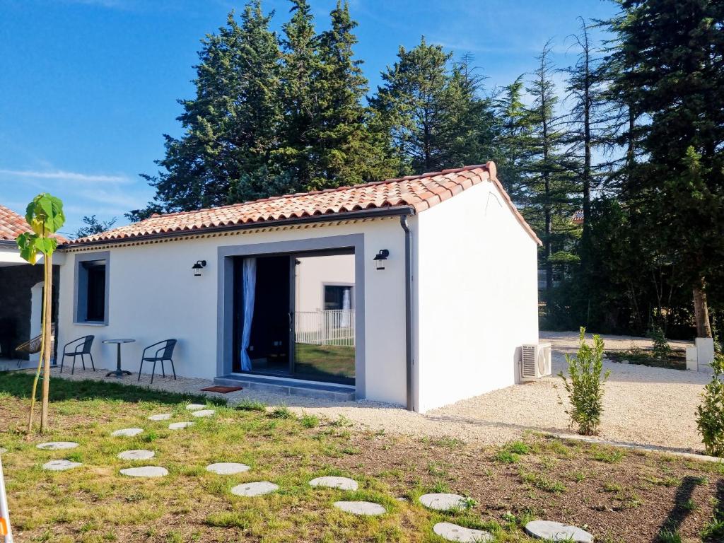 un petit hangar blanc avec une porte dans une cour dans l'établissement Villa climatisée, à Saint-Ambroix