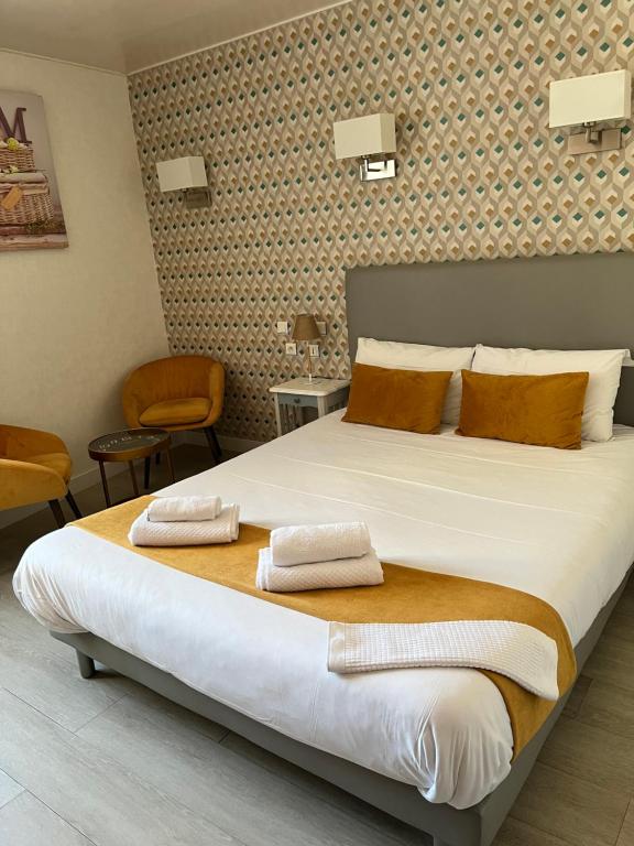 a bedroom with a large bed with two towels on it at Hotel du Nord - Ville-Haute in Saint-Flour