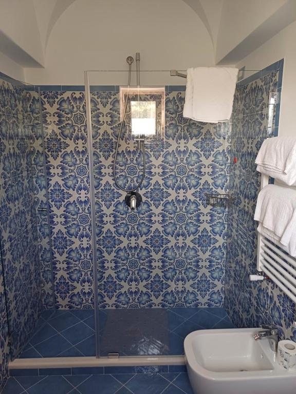a blue tiled bathroom with a shower and a sink at La Casa di Pitti in Anacapri