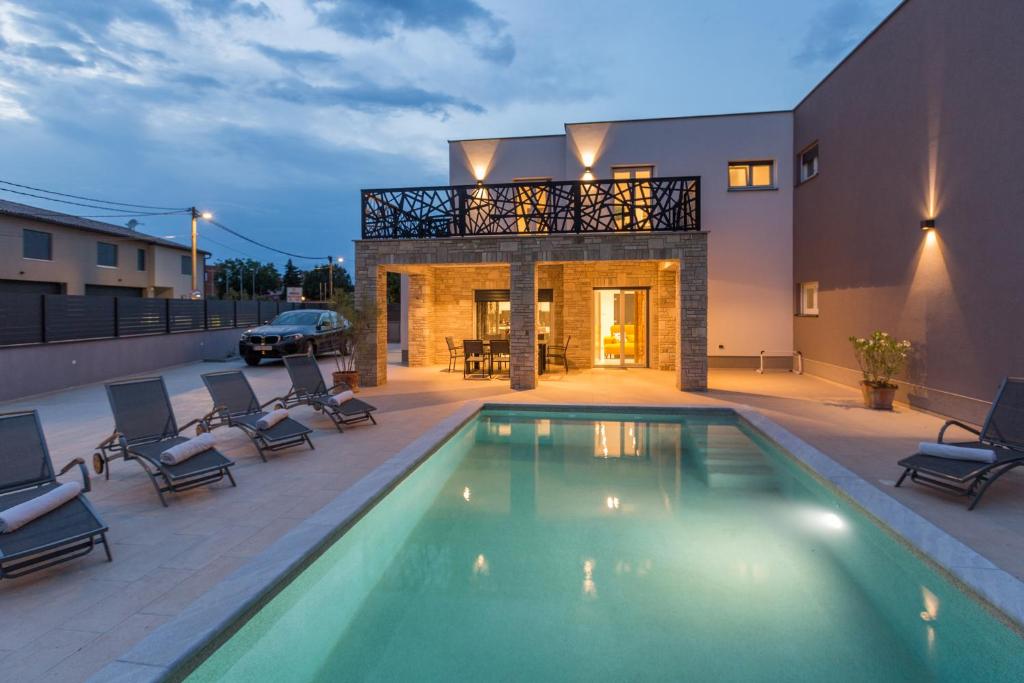 a swimming pool in the backyard of a house at Villa Mirela in Šišan
