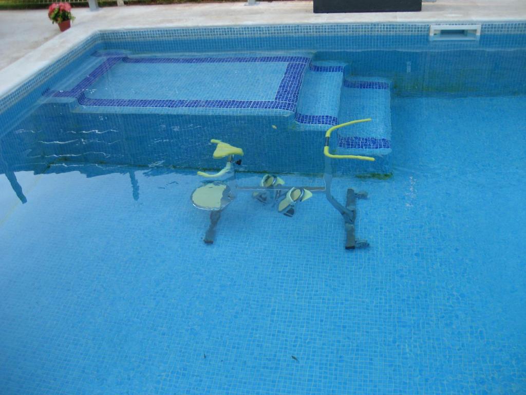 - une piscine avec 2 chaises dans l'eau dans l'établissement Maison avec piscine privée, à Nîmes