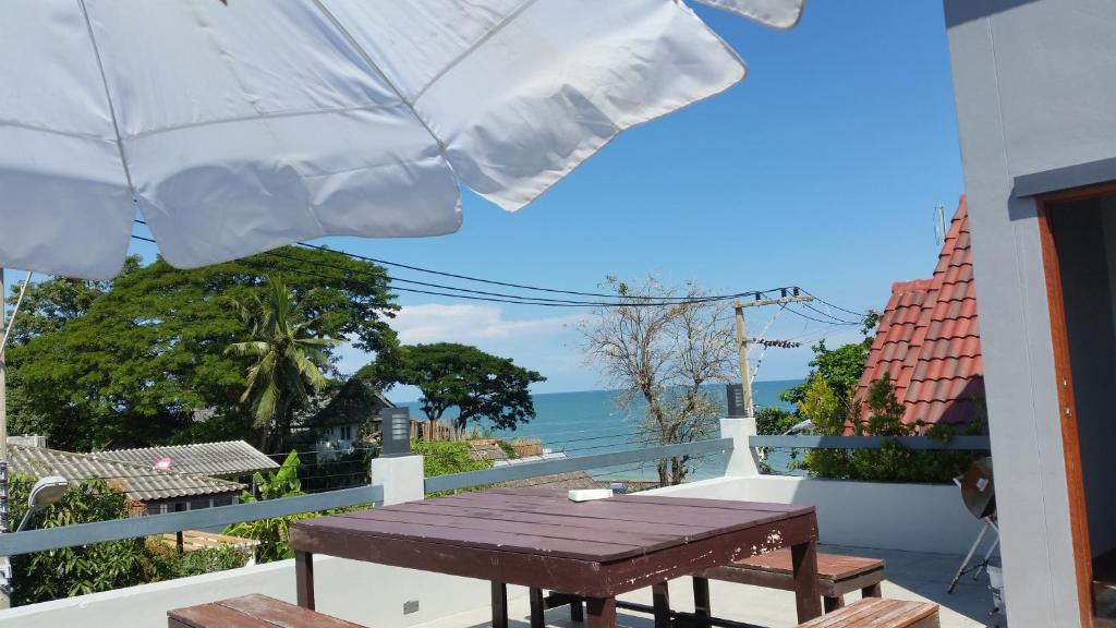 a table on a balcony with a view of the ocean at Hua-Hin Beach Villa บ้านพักริมทะเลหัวหิน in Hua Hin