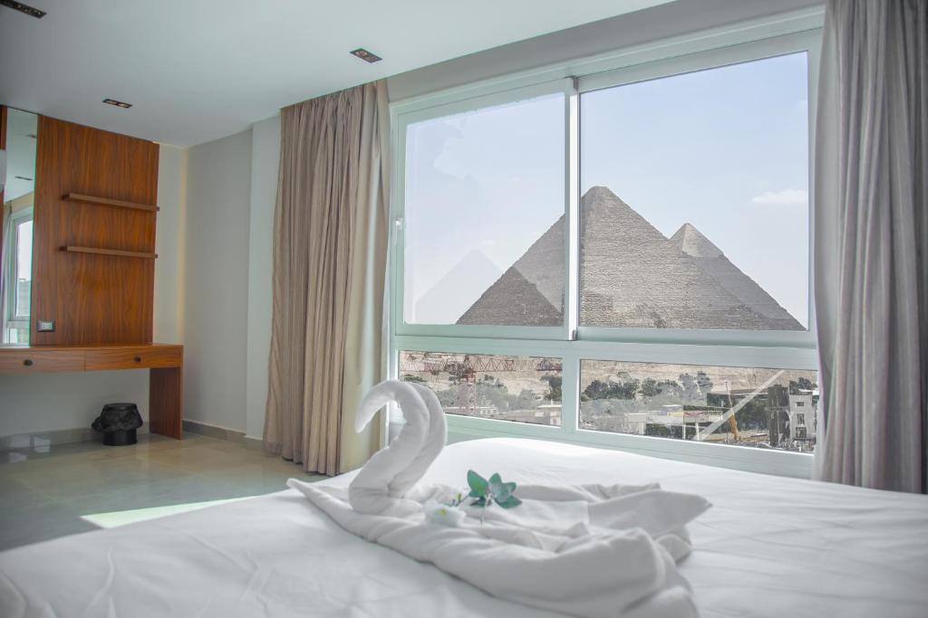 Postel nebo postele na pokoji v ubytování Gaia Pyramids View INN