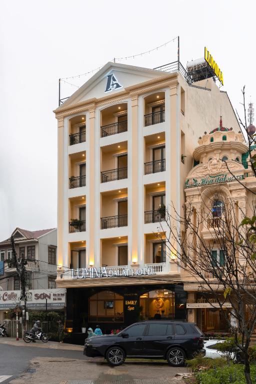 a black car parked in front of a building at Lumina Hotel Da Lat Central in Da Lat