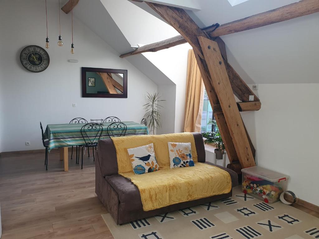 a living room with a couch and a table at Appart avec terrasse, AirCon & parking clos in Montévrain