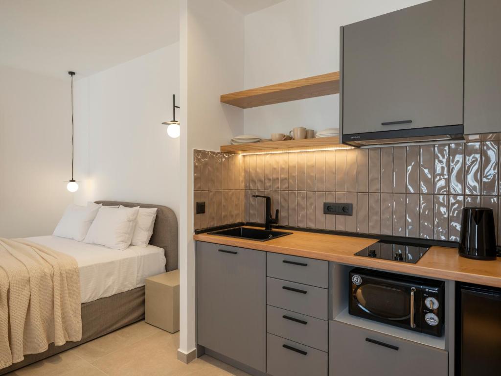 a bedroom with a bed and a kitchen with a sink at Anemelia way of living in Naousa